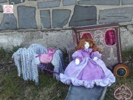 Кукла отдыхает около кареты.